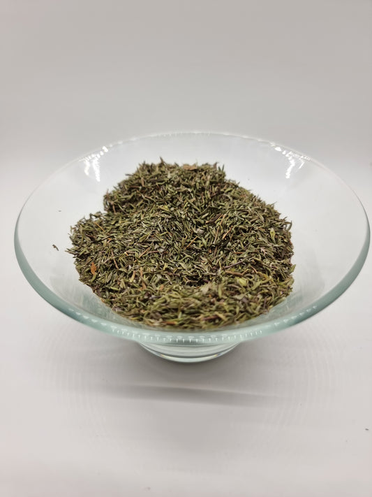 Glass bowl with dried finely chopped thyme leaves green in colour with flecks of brown